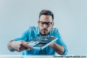 Mann repariert und reinigt Notebook